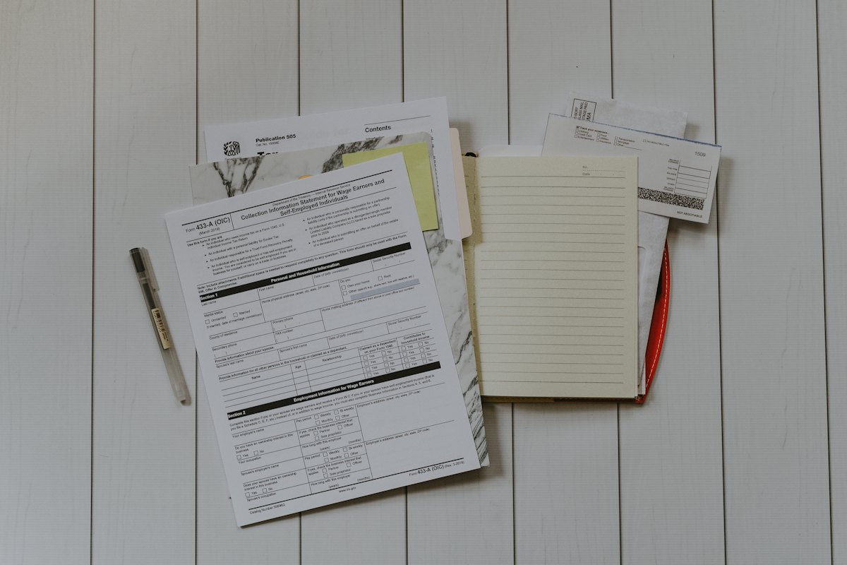 Stack of patent application documents and contracts on a desk